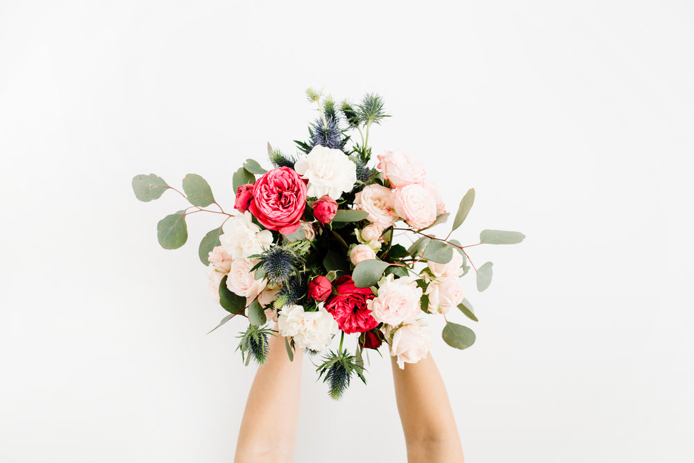 A bouquet of roses, eucalyptus, thistle flowers.