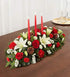 A traditional Christmas centerpiece on a dining table.